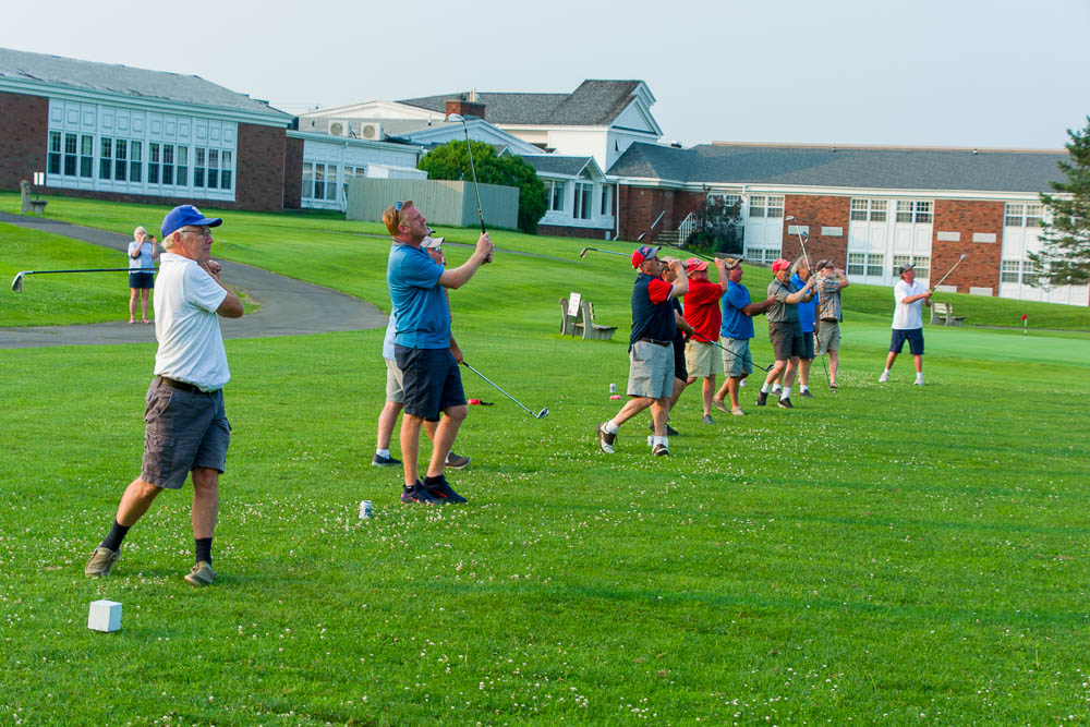 Group photo of Joe Makowiec's golfing buddies hitting balls in his honor at Appleton Golf Course, Saint Lawrence University